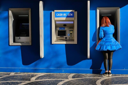 Woman using an ATM machine during the day