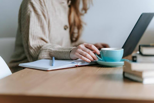 Woman working on a laptop with tax documents at a table