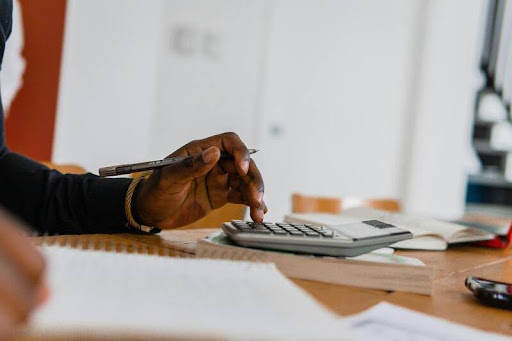 Person using a calculator at a desk in an office setting
