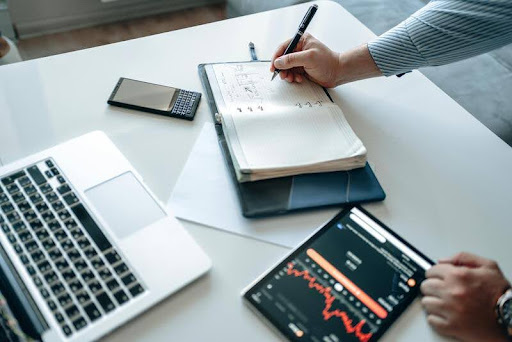 Accountant using a tablet and laptop at a desk