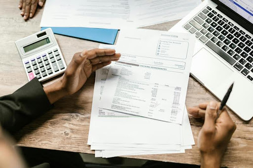 Person reviewing insurance documents with a laptop on a table