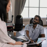 Man showing a woman some documents during a discussion.