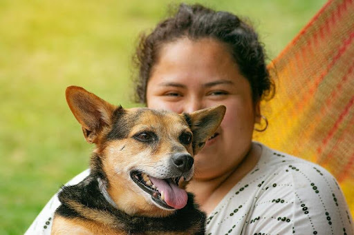 Woman holding her pet dog outdoors