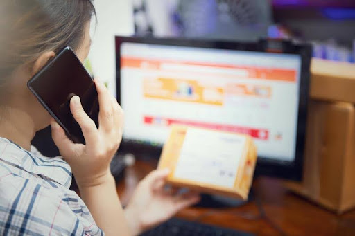 Woman multitasking on the phone while working on a laptop
