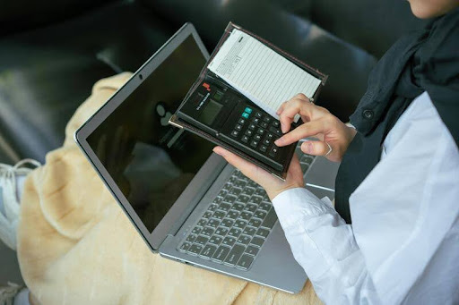 Woman using a smartphone and laptop at a desk