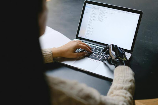 Woman typing on a laptop at a desk.