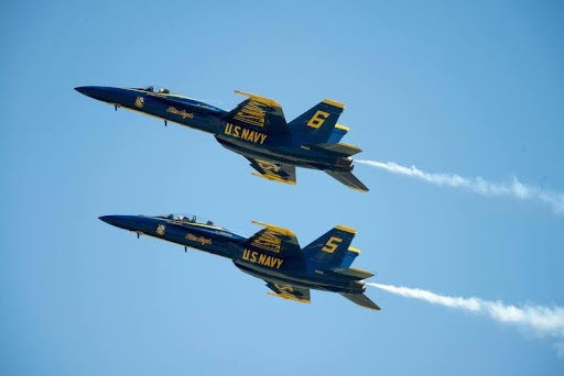 U.S. military fighter jets flying in formation against a clear blue sky.