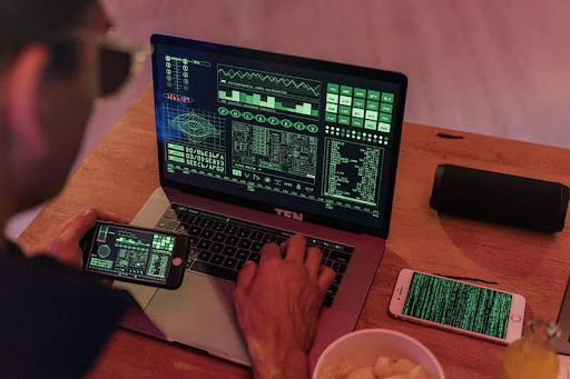 Person focused on a computer screen filled with code.
