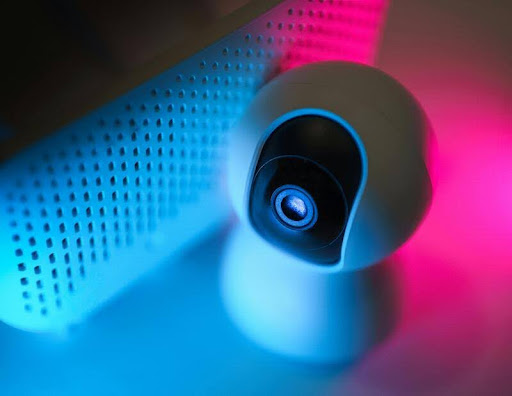 Close-up of a modern smart home security camera with lens and sensors visible.