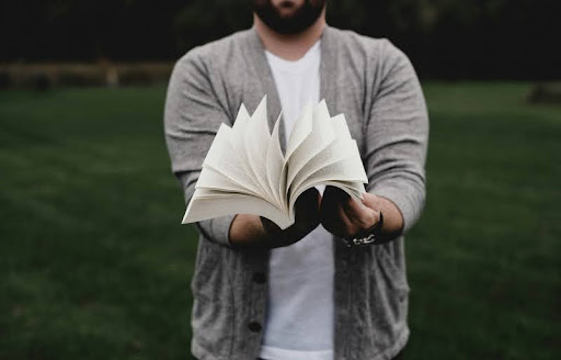 Person opening a book on a desk, ready to study.