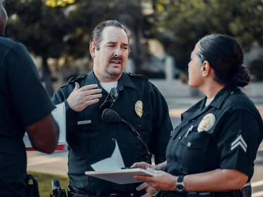 Two police officers talking on a city street