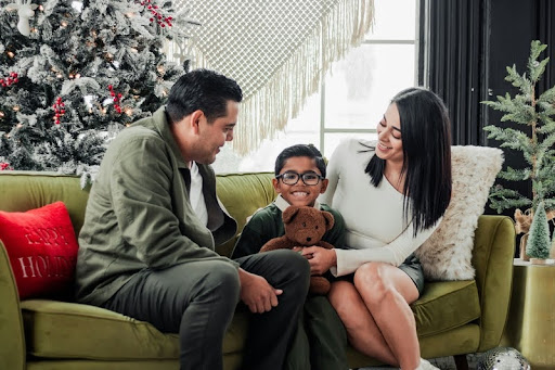 Mother, father, and child sitting on a couch together at home