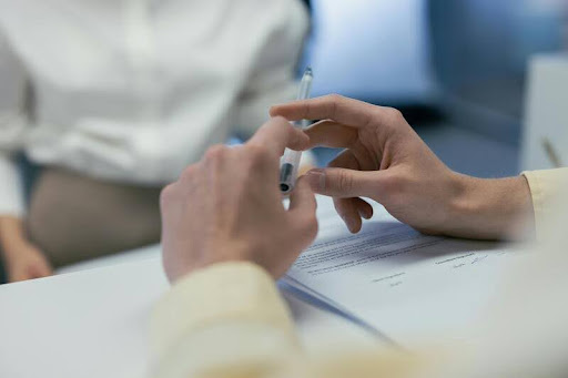Woman reviewing financial documents with a pen in hand