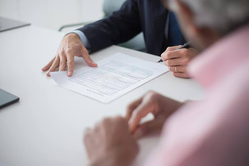 Person signing a document at a desk