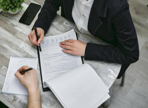 Person holding loan application documents at a desk