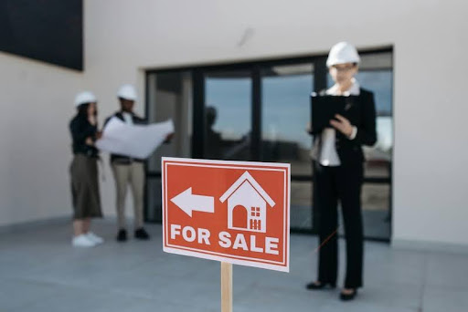 Modern for-sale sign stands in front of a contemporary white house, symbolizing opportunity in today’s real estate market.