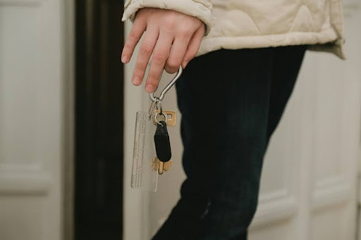 Person holding a golden key in soft light, symbolizing opportunity and success in real estate or investment.