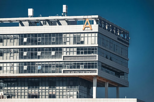 Modern commercial building with sleek glass exterior reflecting the city skyline under bright daylight.