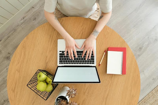 Man working on a laptop in a sleek, modern office with black, white, and gold accents, focused on productivity.