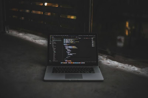 MacBook on a sleek desk displaying code, highlighting modern software development and Web 4.0 dApp creation.