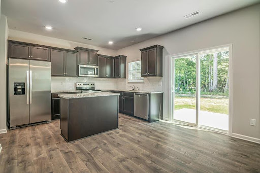 Spacious stainless steel kitchen with minimalist cabinetry, sleek surfaces, and modern lighting in a luxury contemporary home.