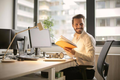 Man working at a sleek desk on a computer, focused on tasks in a modern, minimalist workspace.