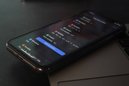 Smartphone resting on a sleek white table, showcasing a modern minimalist design in black, white, and gold accents.